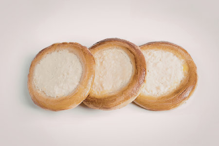 The image features three cream-filled pastries arranged in a row on a white background. The pastries...