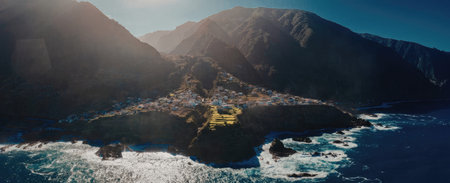 A panoramic view of a coastal town surrounded by mountains and ocean