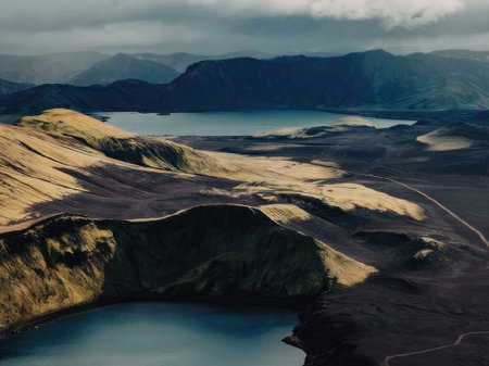 aerial view of a lake surrounded by volcanic landscape with mountains in the background