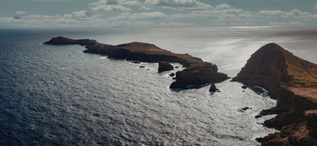 aerial view of ocean and rocky islands with sunlight reflecting on the water surface