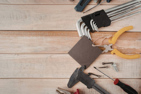 An assortment of hand tools neatly arranged on a wooden surface, ready for various handyman tasks...