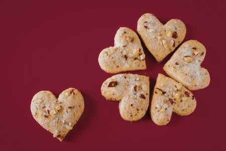 Delicious heart-shaped cookies on red background