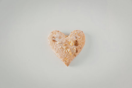 A heart shaped food item on a plain white background, likely a sweet or savory pastry.
