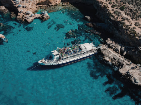 Boat sailing in turquoise waters near rocky cliffs