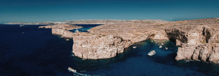 Majestic coastal cliffs with crystal clear waters and boats