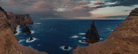 A breathtaking panoramic view of a rugged ocean landscape featuring rocky cliffs and islands at...