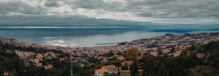 Panoramic view of coastal town under cloudy sky