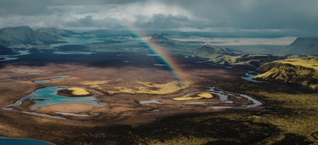 Rainbow over aerial landscape with lakes and mountains