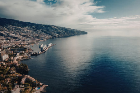 A serene coastal town surrounded by mountains, with a large body of calm water and a few buildings...