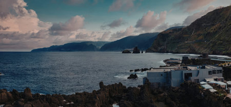 Serene coastal scene with mountains and buildings
