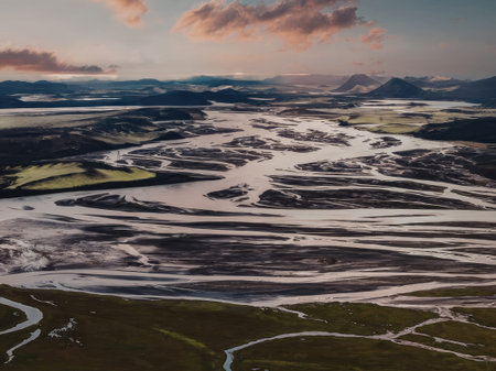 An aerial view of a serene river landscape with meandering waterways, surrounded by lush greenery...