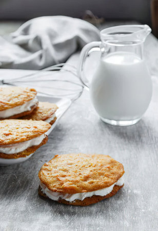 a glass jug of milk and a plate of cookies on a table
