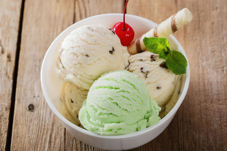 A bowl of assorted ice cream scoops with a cherry on top