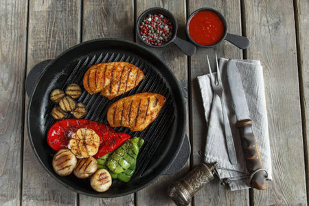A delicious and healthy meal of grilled chicken breast, mushrooms, bell peppers, and onions, served...