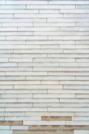 The image displays a close-up view of a brick wall with white and brown bricks arranged in a...