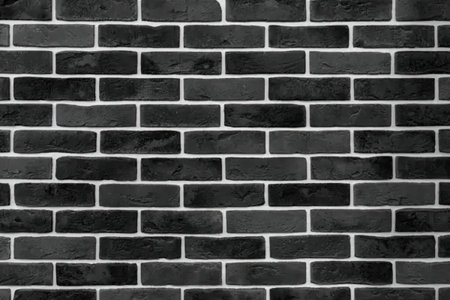 A close-up of a black brick wall with white mortar, showcasing the texture and pattern of the bricks.の写真素材