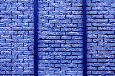 A blue brick wall with two vertical lines running down the center, creating a visually striking pattern.の写真素材