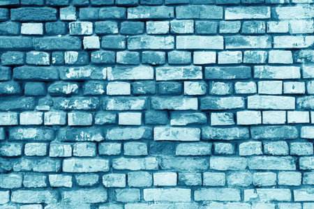 A close-up of a blue brick wall with a textured surface, showcasing the bricks' varying shades of...