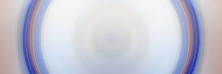 The image features a blurred circular pattern with rainbow hues, predominantly blue and white tones.の写真素材