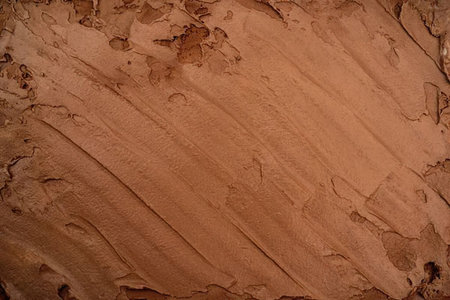 The image displays a close-up view of a rough, textured surface. The surface appears to be made of a...