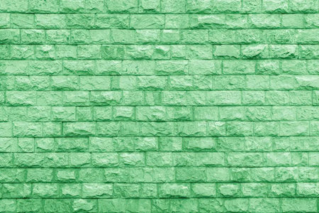 A green painted brick wall background with a textured surfaceの写真素材