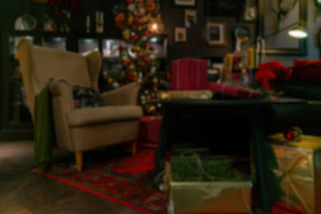 A cozy living room with a wingback chair, coffee table, and Christmas tree decorations.の写真素材