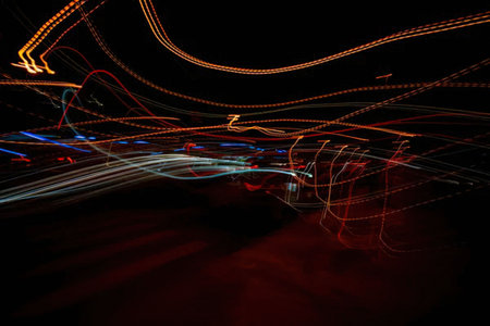 A dark background with colorful light trails moving across, creating a sense of motion and energy.