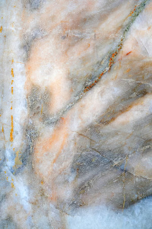 A close-up image of a marble texture featuring a mix of orange, gray, and white hues with prominent...