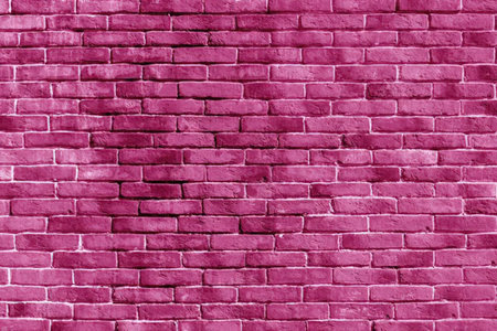 A close-up view of a pink brick wall with a textured surfaceの写真素材