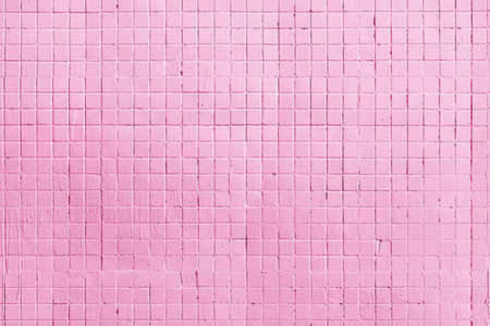 A close-up view of a pink tiled wall with small square tiles