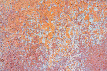 A close-up view of a rusty metal surface with orange and gray hues