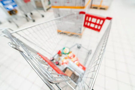 A shopping cart with goods inside, placed on a tiled floor in a store.