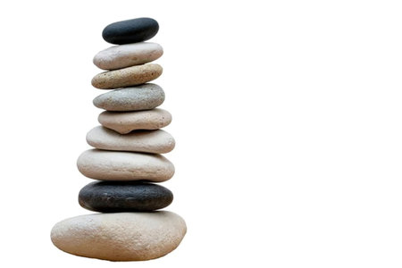 A stack of smooth stones in various shades of brown and black, arranged on top of each other on a...