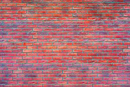 A colorful and vibrant red brick wall with a unique texture, showcasing a blend of red, pink, and...