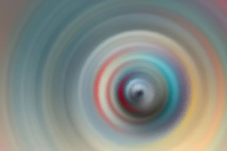 Metallic sphere is surrounded by blurred colorful circular pattern creating a mesmerizing visual...