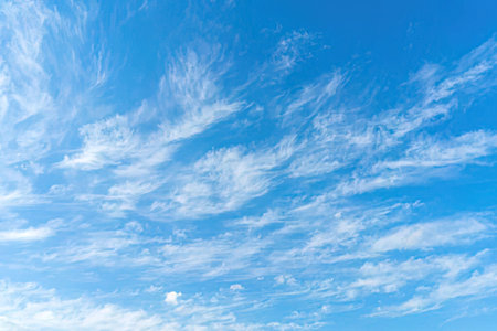 Beautiful blue sky with white clouds on a serene and peaceful sunny day, symbolizing calmness and...