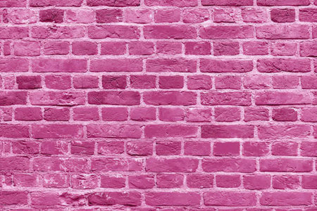 Pink painted brick wall with textured surface, visible mortar, and grunge details, creating a...