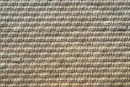 Brick wall with textured surface and color gradient transitioning from dark gray at top to light...