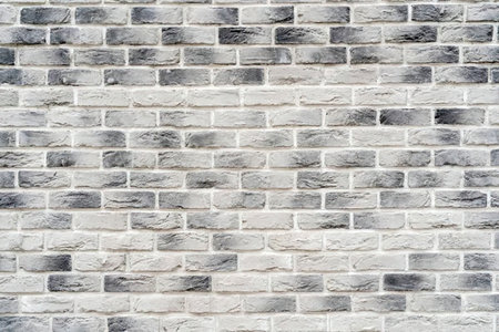 Gray brick wall featuring a textured surface and varied shading, creating a visually appealing...