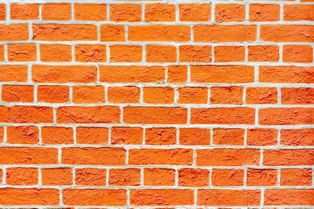 Vibrant red brick wall with textured surface and visible mortar joints creating a detailed...