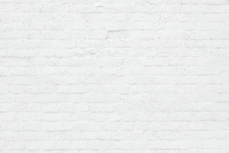White painted brick wall texture provides a clean and minimalist background for various design and...