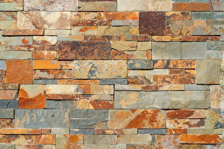Multi colored stone wall featuring irregular shapes and natural stone patterns for decorative...