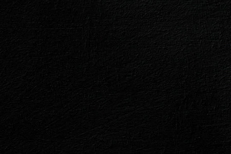 Black textured surface with subtle scratches and imperfections suitable for backgrounds and design...