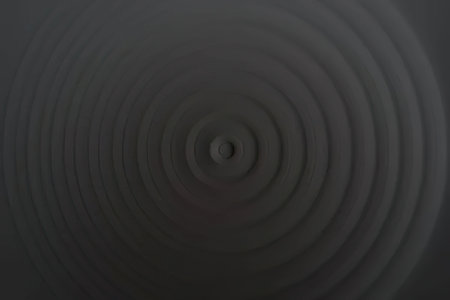 Dark gray spiral pattern with concentric circles creates a sense of depth and movement in a...