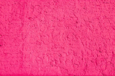 Bright pink rough textured wall surface providing a visually appealing background for creative...