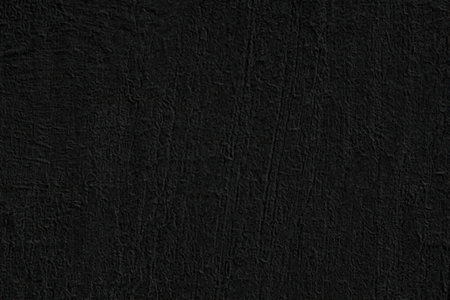 Dark textured background with a rough surface and black color tone for various design purposes...