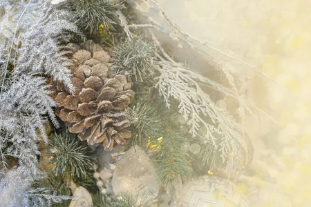 Frosted pine cones and evergreen branches beautifully adorned with snow and festive decorations illuminated in the soft morning light symbolizing winter wonderland scenery.の写真素材