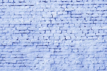 Rough textured brick wall surface painted with a light blue color for architectural design and...