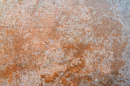 Rusty metal surface exhibits orange and gray hues with a rough grunge texture creating a unique...