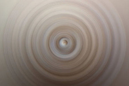 Soft beige spiral pattern creates a hypnotic visual effect with smooth gradient transitions on a clean and minimalist background, perfect for modern design applications.の写真素材